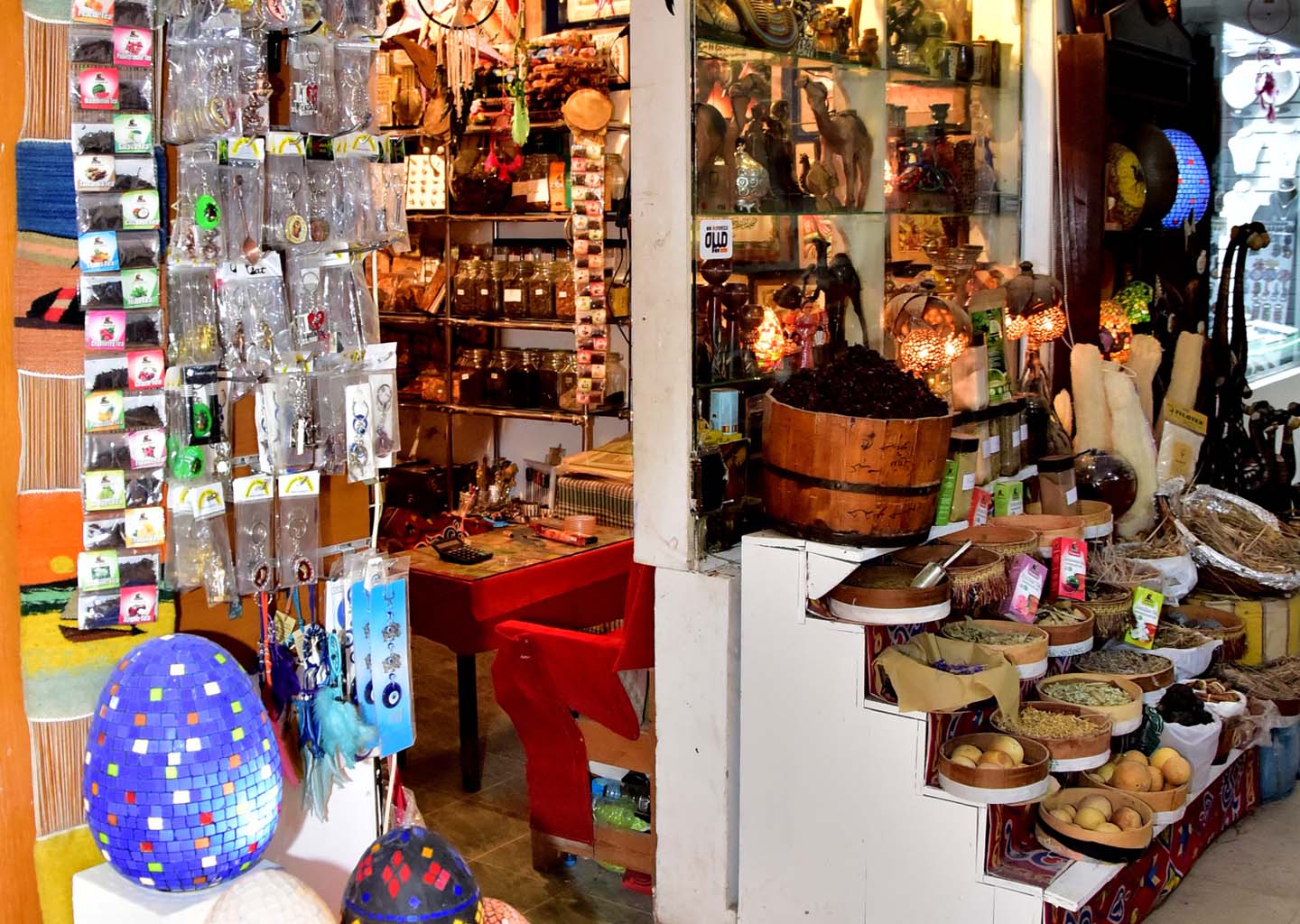 Entrada de una tienda de recuerdos y especias en un mercado de Sharm el-Sheij, Egipto, con cestas de condimentos, lámparas artesanales, llaveros y tés en exposición