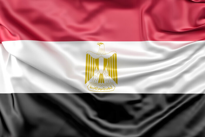 Primer plano de la bandera oficial de Egipto ondeante con textura de seda y el águila dorada central, utilizada como símbolo de identidad de la selección nacional de fútbol de Egipto de cara al Mundial 2026