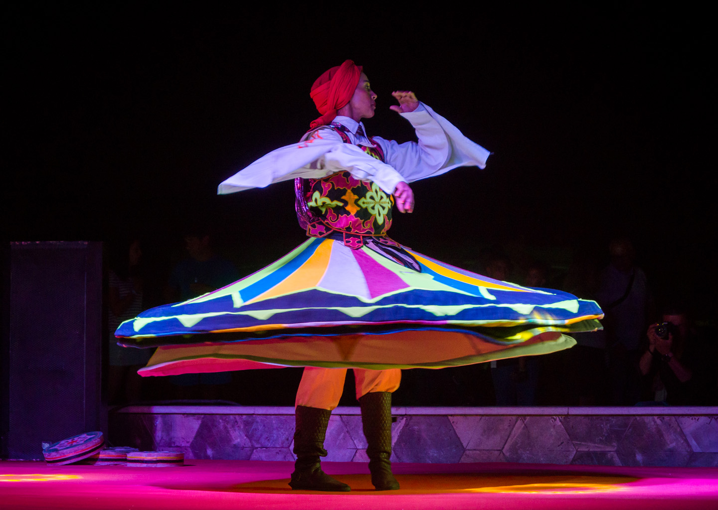 Un bailarín folclórico gira con una falda circular multicolor extendida durante un espectáculo tradicional de Tanura, una de las actividades nocturnas típicas del verano en Egipto