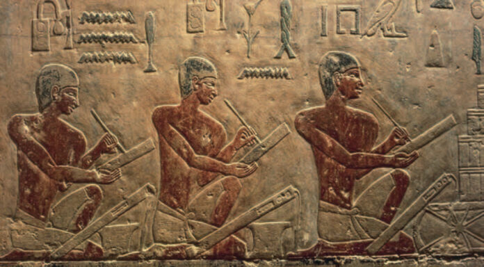 Relieve antiguo en saqqara con jeroglíficos y escribas tallados en piedra, representante de las raíces históricas y la tradición de los idiomas en Egipto