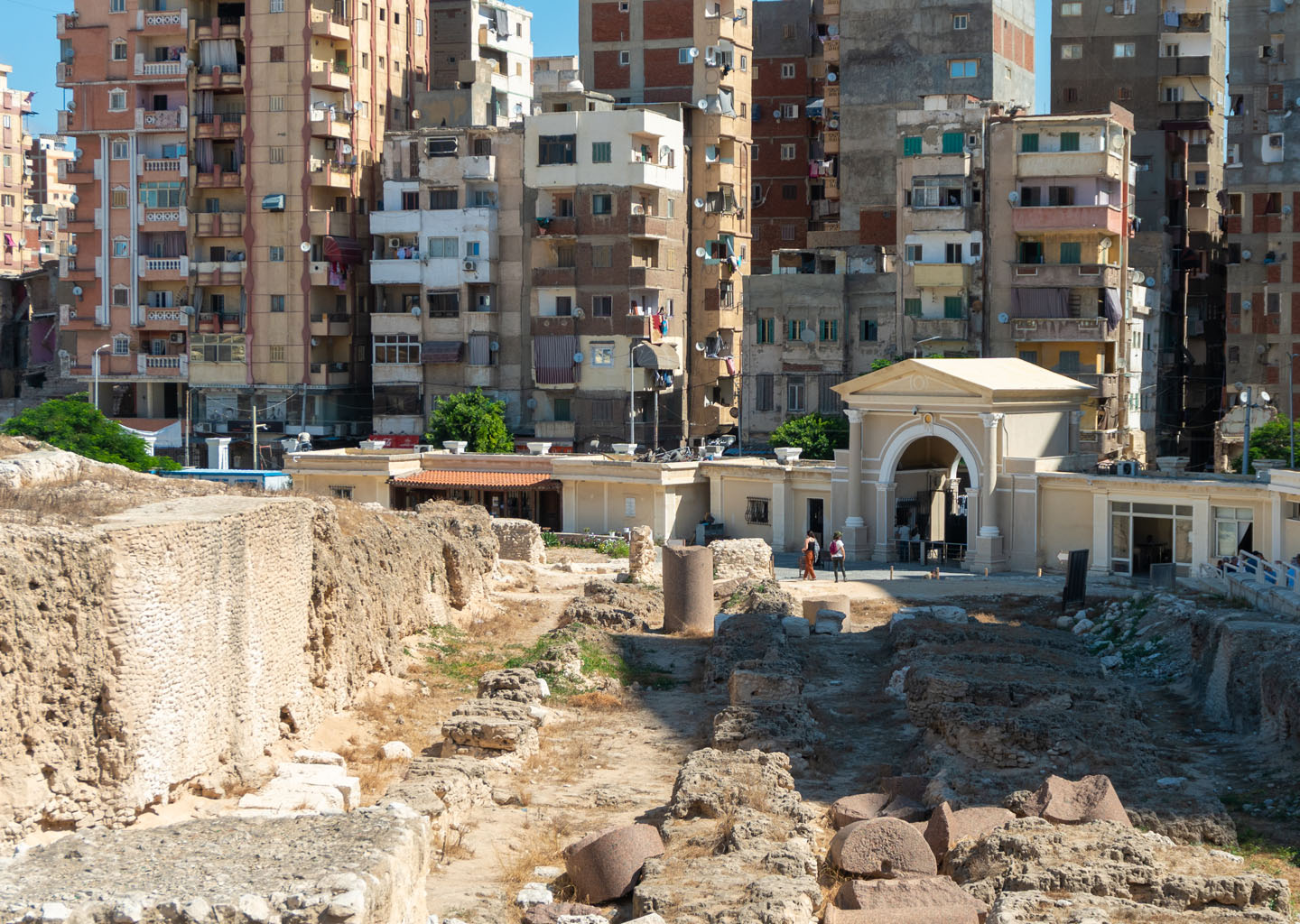 Restos arqueológicos y columnas del Serapeum de Alejandría con edificios al fondo