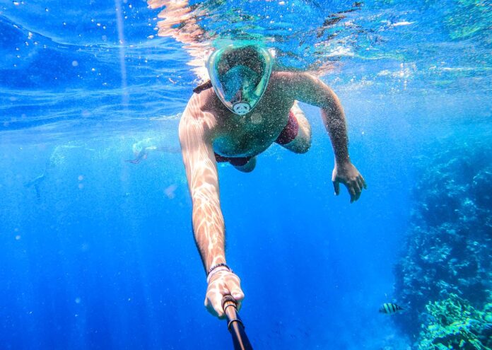 Hombre practicando snorkel con máscara en el mar Rojo, una actividad imprescindible al viajar a Egipto en 2027