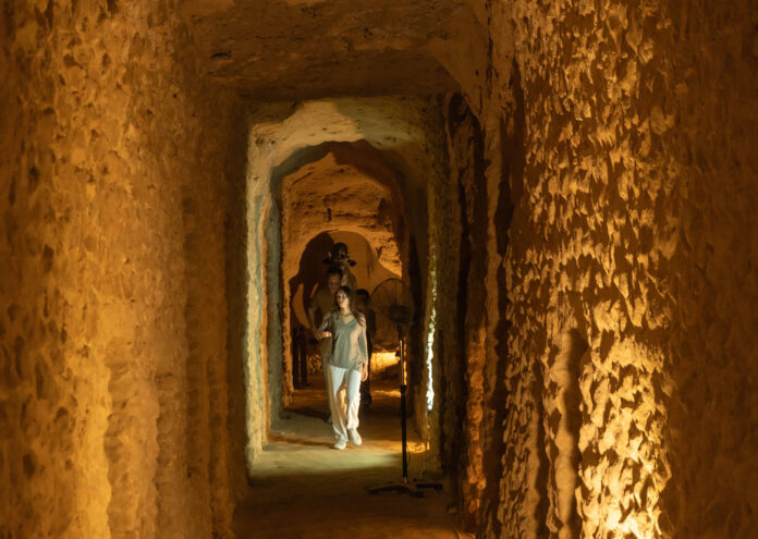 Turistas explorando los túneles subterráneos del Serapeum bajo el Pilar de Pompeyo en Alejandría, una de las maravillas ocultas de Egipto